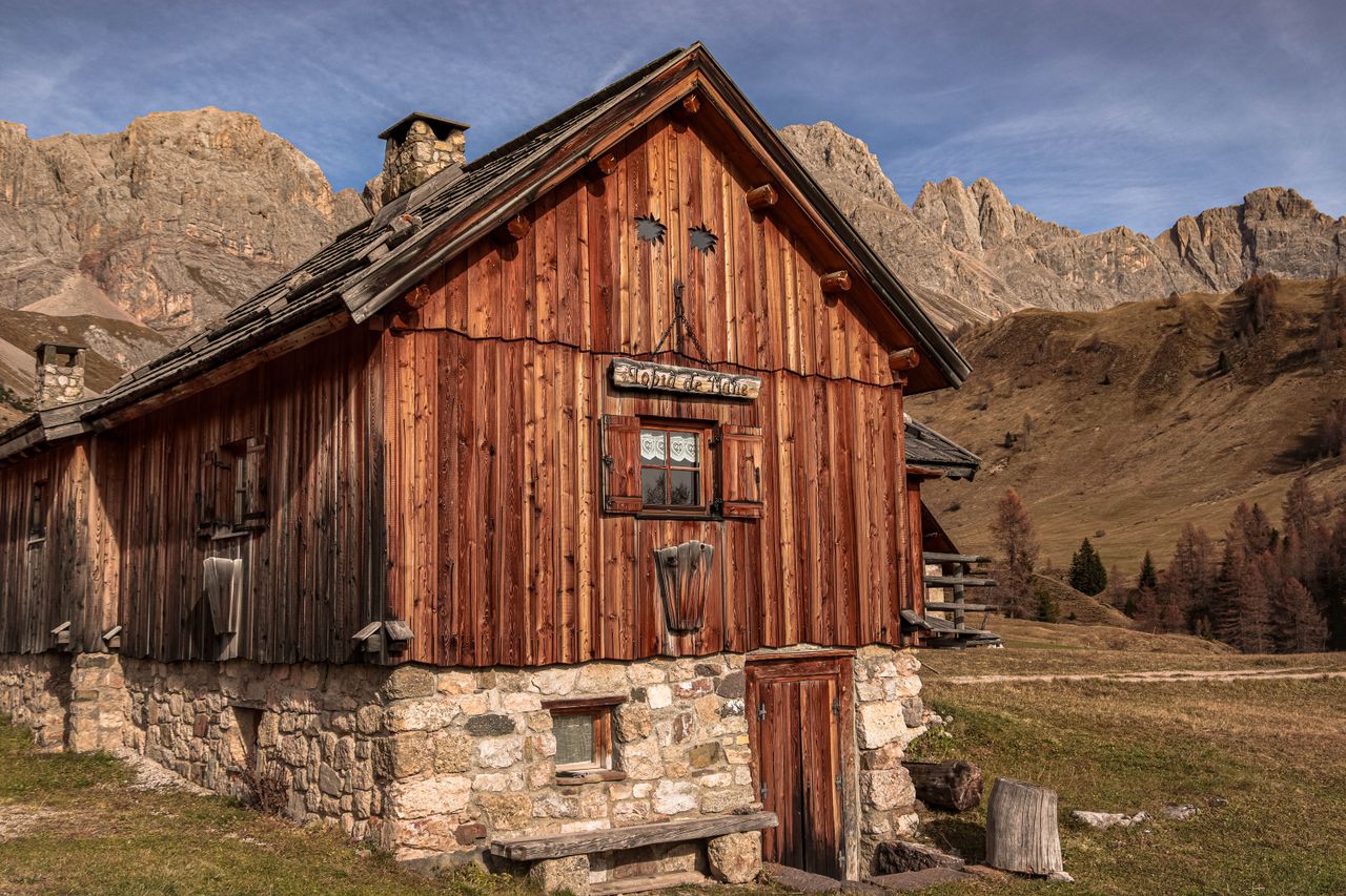 Charming wooden cabin amidst scenic mountain landscape, ideal for travel inspiration.